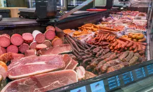Reichhaltige Auswahl an bayerischer Wurst und Schinken, von Salami bis hin zu deftigen Rohwürsten, appetitlich präsentiert in einer Kühltheke.