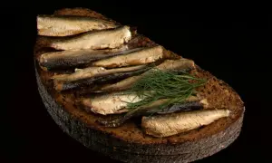 Kanapka z szprotkami na ciemnym chlebie z koperkiem. Czy szprotki są zdrowe? Tak, to bogactwo kwasów omega-3.