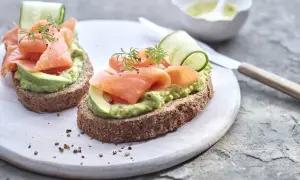 Deux toasts avocat saumon, garniture fraîche avec concombre et aneth, sur pain complet.