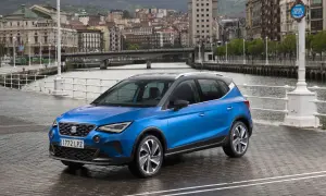Blå Seat Arona parkerad vid en kaj med stad och broar i bakgrunden. Perfekt för en seat arona test i en europeisk stad.
