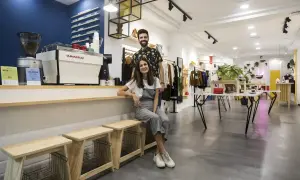 Pareja sonriente en una cafetería y tienda de moda en Zaragoza. Ambiente moderno y acogedor.
