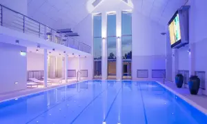 Basen w narie resort & spa, oświetlony niebieskim światłem, z leżakami i dużymi oknami.