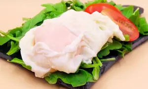 Idealne jajko w koszulce na rukoli z pomidorem. Prosty sposób, jak zrobić jajko w koszulce, by było idealne.