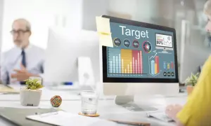 Kobieta analizuje wykresy na ekranie komputera, planując kampanię reklamową w internecie.