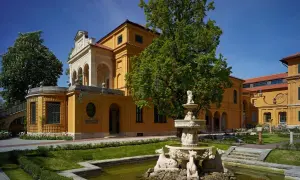 Der kunstbau lenbachhaus mit seinem gelben Anbau und dem Brunnen im Garten.