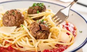 Spaghetti mit drei herzhaften polpetta deutsch, garniert mit Parmesan und Petersilie, serviert mit Tomatensauce.