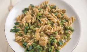 Makaron fusilli z kurczakiem, groszkiem i szczypiorkiem w sosie.