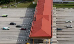 Vue aérienne d'une station de péage avec plusieurs voitures et un camion. Attention à ne pas recevoir d'amende péage en payant votre passage.