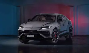 Szary Lamborghini Urus S z czerwonymi zaciskami hamulcowymi stoi w studiu z niebieskim i czerwonym oświetleniem.