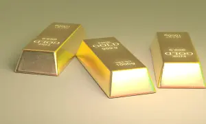 Trzy sztabki złota, każdy o wadze 1000g, z napisem "FINE GOLD 999.9". Ten szlachetny metal lśni w świetle.