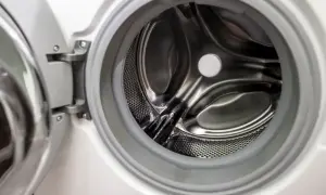 Wnętrze otwartej pralki, z widocznym bębnem. Może to być sygnał, że śmierdzi z pralki i czas na czyszczenie.