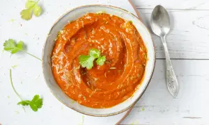 Un tazón de cremosa salsa chipotle, adornado con cilantro fresco y ralladura de lima, listo para acompañar tus platillos.