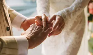 Dłoń pana młodych zakłada obrączkę na palec panny młodej. Ten moment, jak wzruszające piosenki na ślub, na zawsze pozostanie w sercu.