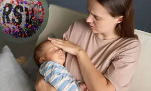 Zmartwiona mama sprawdza gorączkę u niemowlaka. W tle wirus RSV, który może być groźny dla maluchów.