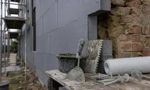 Attrezzi da cantiere e materiali per cappotto termico. Si intravedono mattoni a vista, forse un limite di questo sistema.