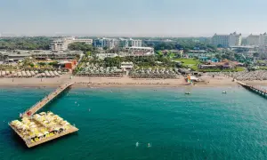 Traumhafter Blick auf das Limak Atlantis De Luxe Hotel & Resort mit Strand, Steg und türkisfarbenem Meer.