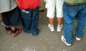 Luźne spodnie, szerokie nogawki i sportowe buty – to wszystko w stylu hip hop. Grupa młodych ludzi w luźnych ubraniach.