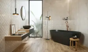 Nowoczesna, biała łazienka z drewnem i czarnymi dodatkami. Wolnostojąca wanna, umywalka i armatura w miedzianym odcieniu tworzą elegancką całość.