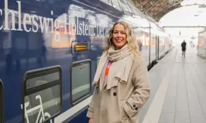 Frau am Bahnsteig in Schleswig-Holstein, bereit für neue Abenteuer. Hier sind einige Flensburg Tipps für deine Reise!