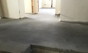 Surowy, betonowy jastrych co to? To podłoga gotowa na wykończenie. Widać fragmenty ścian i instalacji.