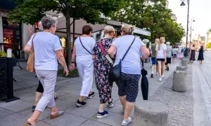 Grupa kobiet po 60-tce spaceruje po mieście. Być może rozmawiają o możliwościach, jakie daje stały zasiłek dla bezrobotnych po 60 roku życia.
