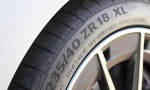 Gros plan sur un pneu de voiture avec l'inscription "235/40 ZR 18 XL", indiquant une capacité de charge renforcée pour une conduite sportive.
