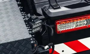 Feu arrière LED d'un véhicule tout-terrain, avec une bande réfléchissante rouge et blanche. Un projecteur auxiliaire est monté à proximité, conforme à la norme IP63.