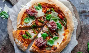 En härlig italiensk pizza med sparris, parmaskinka, champinjoner och färsk basilika.
