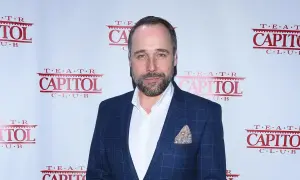 Łukasz Nowicki, znany z wielu filmów, pozuje na tle ścianki z logo Teatru Capitol.