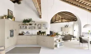 Jasna kuchnia shabby chic z drewnianymi belkami na suficie, wyspą i otwartą przestrzenią z sofą.