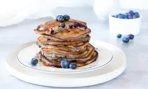 Ein Stapel Blaubeerpfannkuchen, garniert mit frischen Blaubeeren. Dieses Blaubeerpfannkuchen Rezept ist ein Genuss!