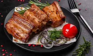 Soczyste żeberka w coli, podane z pomidorkiem, cebulą i rozmarynem. Idealne na obiad.