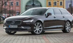 Brązowe Volvo V90 na tle kamienic. Sprawdź akcje serwisowe Volvo po VIN, aby upewnić się, że Twój samochód jest bezpieczny.