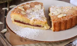 Fette di crostata frangipane con marmellata e mandorle, spolverate di zucchero a velo.