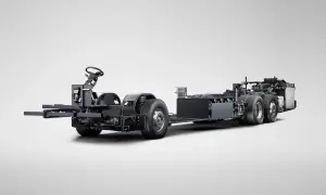 Châssis d'un bus Scania hybride, prêt à être assemblé, avec son volant et ses roues visibles.