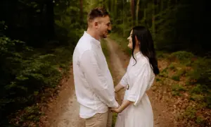 Para zakochanych trzymających się za ręce na leśnej ścieżce. Piękne zdjęcia w lesie.