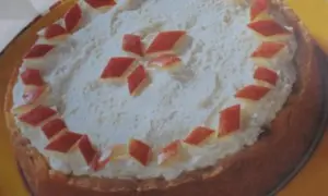 Eine köstliche Apfel Sekt Torte mit Sahnehaube und roten Apfelstücken verziert.