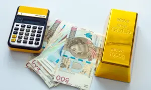 Kalkulator, polskie banknoty 500 zł i sztabka złota 1000g. Zastanawiasz się, ile kosztuje 1 uncja złota?