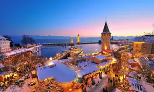Winterzauber am Hafenweihnacht Lindau: Lichterglanz, Schnee und Menschenmassen vor dem alten Wasserturm und den Leuchttürmen.
