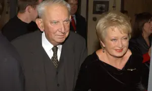 Gustaw Holoubek z żoną, uśmiechnięci, w eleganckich strojach.