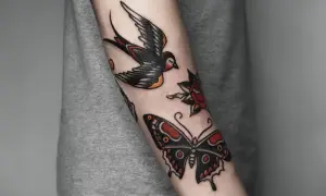 Tatuaż w stylu old school na przedramieniu: jaskółka, motyl i róża.