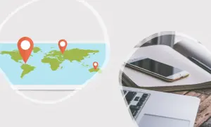 Weltkarte mit Markierungen für einen Deutschland-Trip. Daneben ein Laptop, Smartphone und Notizbuch.