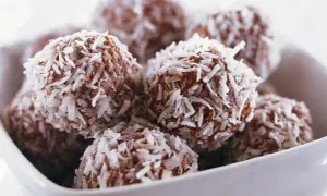 En skål med nyttiga chokladbollar, rullade i kokosflingor. Perfekta för fikat!