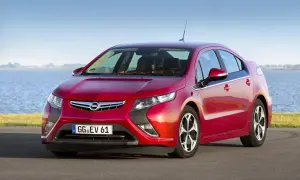 Czerwony Opel Ampera stoi nad jeziorem, gotowy na ekologiczną podróż.