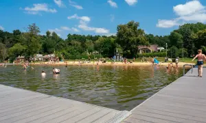 Słoneczny dzień na kąpieliskach w Poznaniu. Ludzie kąpią się, opalają na plaży i odpoczywają nad wodą.
