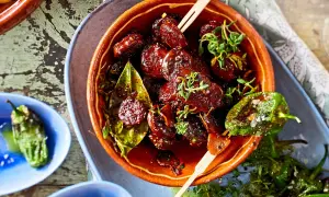 Leckeres Tapas Fingerfood: Glasierte Datteln mit Kräutern und geröstete Pimientos de Padrón.