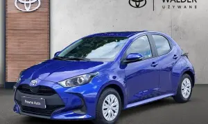 Niebieska Toyota Yaris przed salonem Walder Używane. Zastanawiasz się, ile kosztuje wymiana łożyska w Toyocie Yaris?