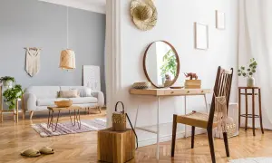Accogliente soggiorno con divano grigio, tavolino in legno e una **stanza buia** con specchio rotondo e scrivania.