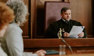 Sędzia w todze analizuje dokumenty, zastanawiając się, jakie pytania zadać na rozprawie o ograniczenie praw rodzicielskich.