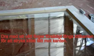 Fönsterkarm med nyligen applicerat kitt. Dra med ett vått finger längs kittkanten för att jämna till.
